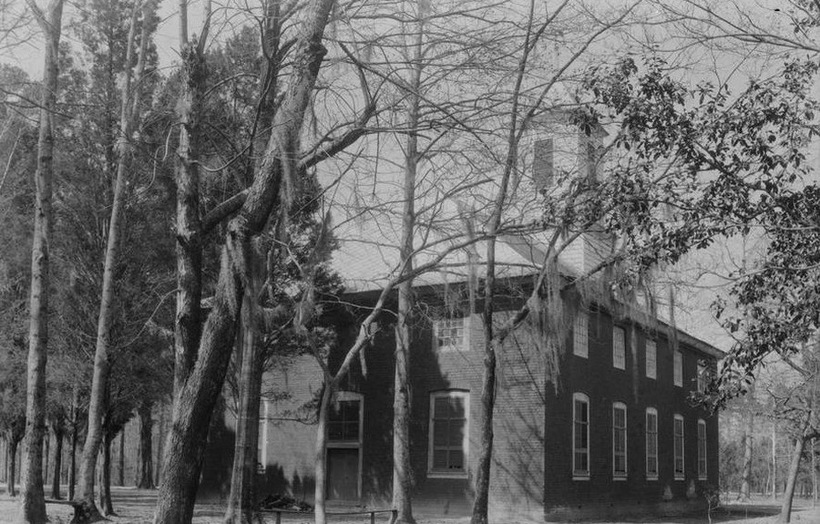 Black-and-white photo from 1934 of the church from the northwest, among trees.