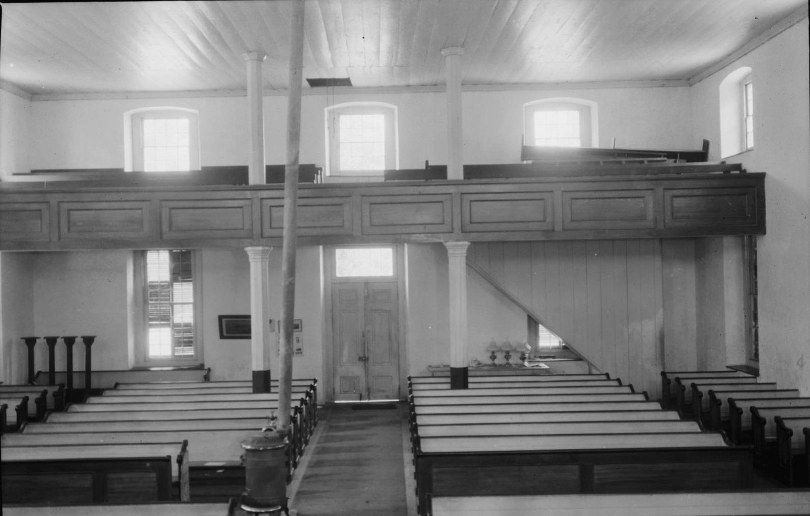 Black-and-white photo from 1934 of the church interior looking south, with the gallery and wooden pews.